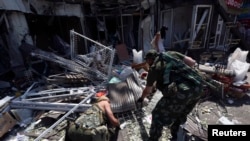 Rusya yanlısı isyancılar Ukrayna hava saldırısında yıkıldığı söylenen bir bina enkazını incelerken