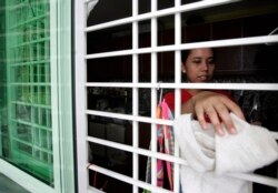 Pembantu asal Indonesia membersihkan rumah majikannya di Kuala Lumpur 26 Juni 2009. (Foto: Reuters)