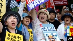 FILE - Anti-U.S. base protesters shouts slogans at a rally in front of the National Diet building on June 19, 2016. 