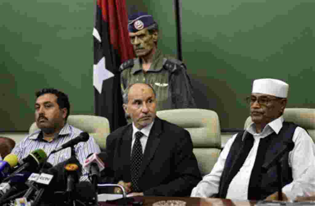 Mustafa Abdul-Jalil, en el centro, jefe del gobierno interino del Consejo Nacional de Bengasi entrega su declaración a la prensa.