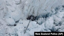 The wreckage of a helicopter carrying tourists is seen crashed in a crevasse on Fox Glacier, a scenic glacier in South Island, New Zealand, Nov. 21, 2015. All seven people, one pilot and six tourists, aboard the helicopter are believed to have been killed.