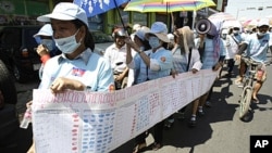 Cambodian protesters from Boueng Kak lake march with a banner displaying the thumb prints of fellow land owners who have been evicted from their homes, as they demand compensation, in Phnom Penh, Cambodia, May 4, 2012. 