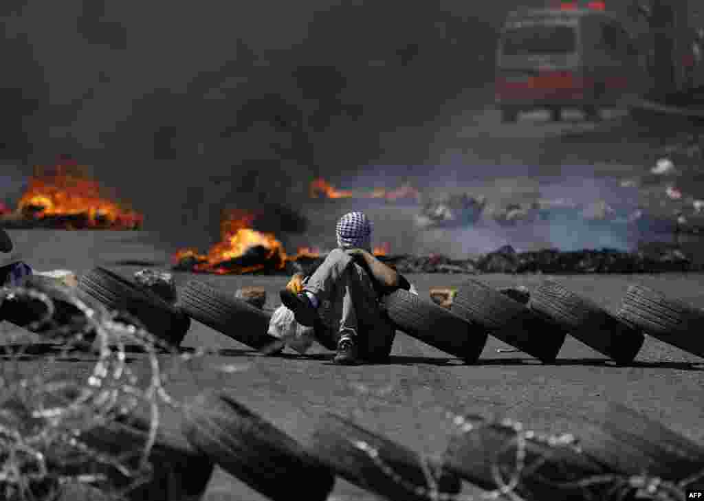 Palestinian men burn tires during a protest in the West Bank city of Ramallah.