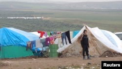 A Syrian refugee looks on in a refugee camp on the Syrian side of the border with Turkey, near Idlib, January 29, 2013.
