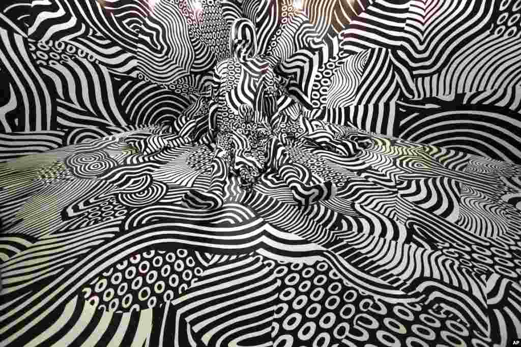 A Model poses in an art installation "Narcissism : Dazzle room" by artist Shigeki Matsuyama at fashion and design exhibition in Tokyo, Japan.