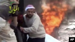 This image provided by Shaam News Network, which has been authenticated, shows a wounded man being pulled from the site of a Syrian government airstrike on a gas station in the eastern Damascus suburb of Mleiha, Syria, Jan. 2, 2013. 