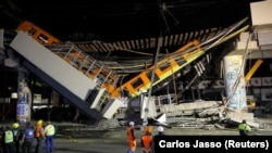 Jembatan layang untuk metro, terlihat runtuh sebagian dengan gerbong kereta di atasnya di stasiun Olivos, Mexico City, Meksiko 4 Mei 2021. REUTERS / Carlos Jasso
