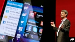 Thorsten Heins, presiden dan CEO Blackberry, memegang BlackBerry 10 yang baru di sebuah konferensi di Orlando, Florida (14/5).