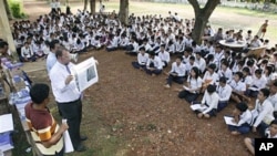 The officers of U.N.-backed genocide tribunal meet high school students at Ek Phnom district in Battambang province, as they distribute recent verdict books of Khmer Rouge leader Kaing Guek Eav, northwest of Phnom Penh, Cambodia, May 5, 2011. 