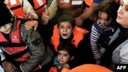 Des réfugiés syriens après le naufrage de leur embarcation près de l'île grecque de Lesbos, 30 oct. 2015. (AFP/ARIS MESSINIS)