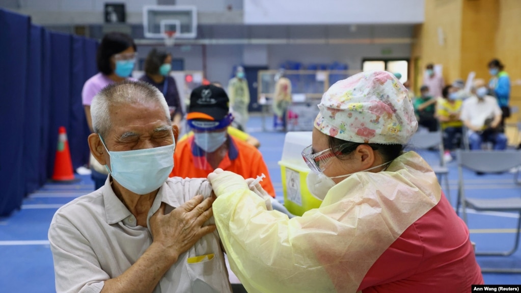 FILE PHOTO: A medical worker administers a dose of the AstraZeneca vaccine to a man during a vaccination session for elderly people over 75 years old, at a stadium in New Taipei City, Taiwan June 25, 2021.