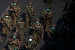 Tentara Myanmar dari divisi infanteri ringan ke-77 berjalan di sepanjang jalan selama protes terhadap kudeta militer di Yangon, Myanmar, 28 Februari 2021. (Foto: Reuters)