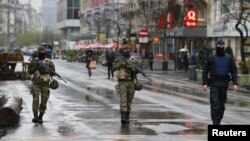 Belgian soldiers and a police officer patrol in central Brussels after security was tightened in Belgium following the fatal attacks in Paris, Nov. 21, 2015.