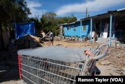 The Le family spends a Saturday afternoon cleaning the lot of their flood-damaged mobile home, which has since been replaced.