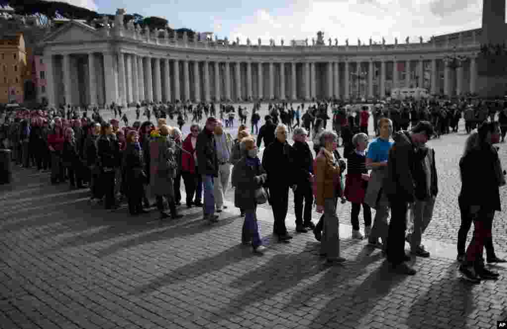 Visitors line up as they wait their turn to enter Saint Peter&#39;s Basilica at the Vatican, Monday, March 11, 2013.