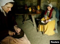 FILE – Reactors dressed as Pilgrims prepare a meal at Plimoth Plantation in Plymouth, Massachusetts in this 2004 file photo.