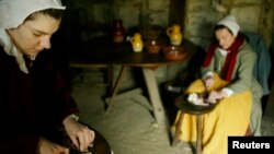 Re-enactors dressed as Pilgrims prepare a meal at Plimoth Plantation in Plymouth, Massachusetts in this 2004 file photo.