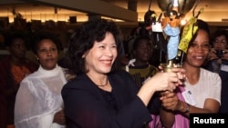FILE - U.N. official Noeleen Heyzer from Singapore, left, holds the "peace torch" with Zambia's Inonge Mbikusita Lawineka at the opening of a conference in The Hague on May 12, 1999.