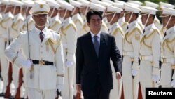 Japan's Prime Minister Shinzo Abe reviews the honour guard before a meeting with Japan Self-Defense Force's senior members at the Defense Ministry in Tokyo, Sept. 12, 2013. 