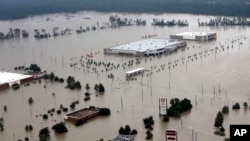 In this Tuesday, Aug. 29, 2017, file photo, businesses are surrounded by floodwaters from Harvey, in Humble, Texas. (AP Photo/David J. Phillip, File)