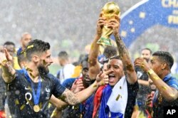 France's Olivier Giroud, left, and France's Corentin Tolisso, center, celebrate after winning 4-2 in the final match between France and Croatia at the 2018 soccer World Cup in the Luzhniki Stadium in Moscow, Russia, July 14, 2018.