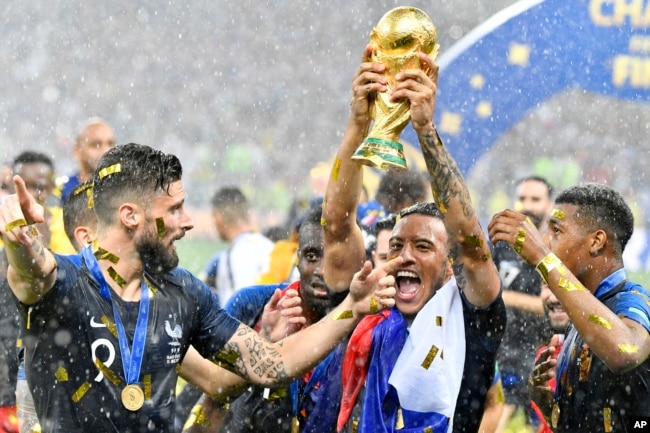 France's Olivier Giroud, left, and France's Corentin Tolisso, center, celebrate after winning 4-2 in the final match between France and Croatia at the 2018 soccer World Cup in the Luzhniki Stadium in Moscow, Russia, July 14, 2018.