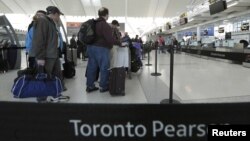 Para penumpang antri untuk check-in di loket penerbangan Air Canada di bandara Pearson International, Toronto (Foto: dok). Lebih dari 200 penerbangan hari Natal di bandara ini telah dibatalkan akibat ancaman badai salju yang diramalkan akan melanda pantai Timur Amerika.