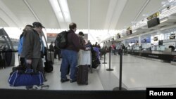Des passagers d’Air Canada à l’aéroport international de Pearson Toronto se faisant enregistrer, le 13 avril 2012.