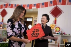 美国第一夫人梅拉尼娅·特朗普和中国国家主席习近平夫人彭丽媛访问北京板厂小学，两人手持学生写的福字（2017年11月9日）。