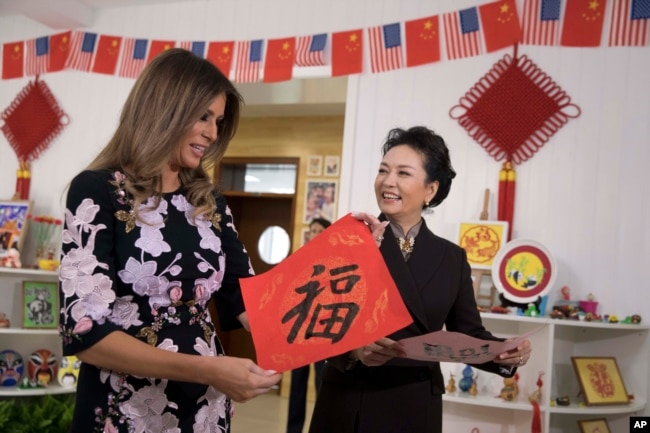 美國第一夫人梅拉尼婭·特朗普和中國國家主席習近平夫人彭麗媛訪問北京板廠小學，兩人手持學生寫的福字（2017年11月9日）。