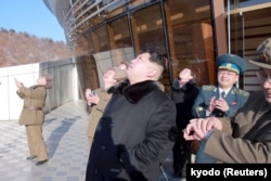 Lãnh tụ Bắc Triều Tiên Kim Jong Un (giữa) xem hỏa tiễn được phóng đi trong một bức hình do hãng tin Kyodo cung cấp, ngày 7 tháng 2, 2016.