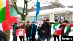 FILE - Iranian exiles shout slogans in front of a mock gallows to protest against executions in Iran during a demonstration outside the Iranian Embassy in Brussels, Dec. 29, 2010. Iran researcher Raha Bahreini said June, 27, 2018, that said Amnesty International was outraged that Iranian authorities had not taken steps to end what she called the "horrendous practice of executing juvenile offenders."