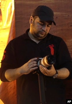 FILE - Jawad Nasrallah, the second-eldest son of Hezbollah leader Sheikh Hassan Nasrallah, adjusts his camera during a speech by his father, in suburban Beirut, Lebanon, Nov. 3, 2014. Jawad has been designated by the U.S. State Department as a global terrorist.