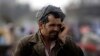 FILE - An Afghan man talks on his mobile phone on a street in Kabul, March 24, 2011. Taliban insurgents recently shut down private telecommunication companies in several parts of the country.