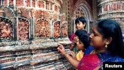 FILE - Visitors at Kantajir Mandir, one of Bangladesh's oldest Hindu temples, examine thousands of clay idols and historic images on the temple's walls. Photo taken July 1995. Ten people were hurt in bomb blasts at the temple, Dec. 5, 2015. 