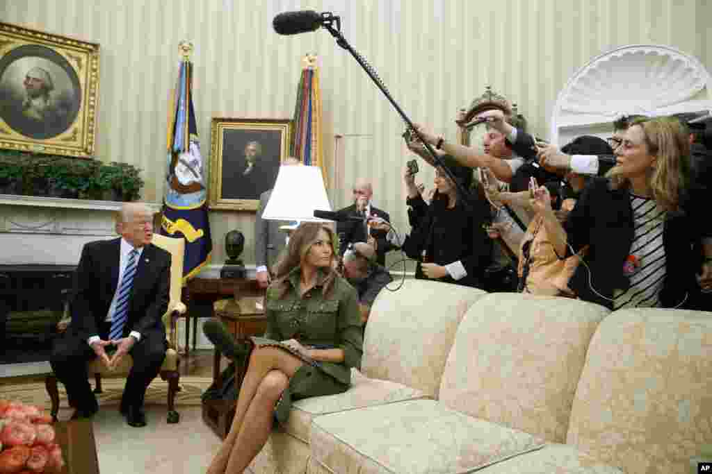 First lady Melania Trump listens as her husband President Donald Trump speaks to reporters during a meeting with Argentine President Mauricio Macri his wife Juliana Awada in the Oval Office of the White House.