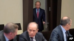FILE - Federal Security Service (FSB) Chief Alexander Bortnikov (front, center) is seen at a Security Council meeting in the Novo-Ogaryovo residence outside Moscow, Russia, April 13, 2017, with Russian President Vladimir Putin entering in the background.