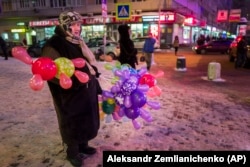 RUSSIA -- An elderly woman sells colored balloons to earn extra money for her retirement standing near a big shopping mall in Moscow, January 25, 2016