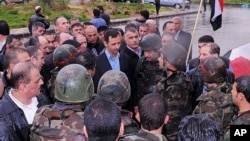 This July 31, 2013, screen grab from the official Instagram account of the Syrian Presidency purports to show Bashar Assad visiting with soldiers in Baba Armr, Homs province, Syria, in 2012. 