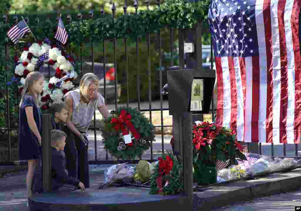 У ворот дома экс-президента США Джорджа Буша-старшего в Хьюстоне, Техас, люди возлагают цветы в память о покойном президенте
