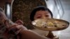 FILE - A North Korean boy peeps over his serving of noodles at a restaurant in Pyongyang, Sept. 1, 2014.