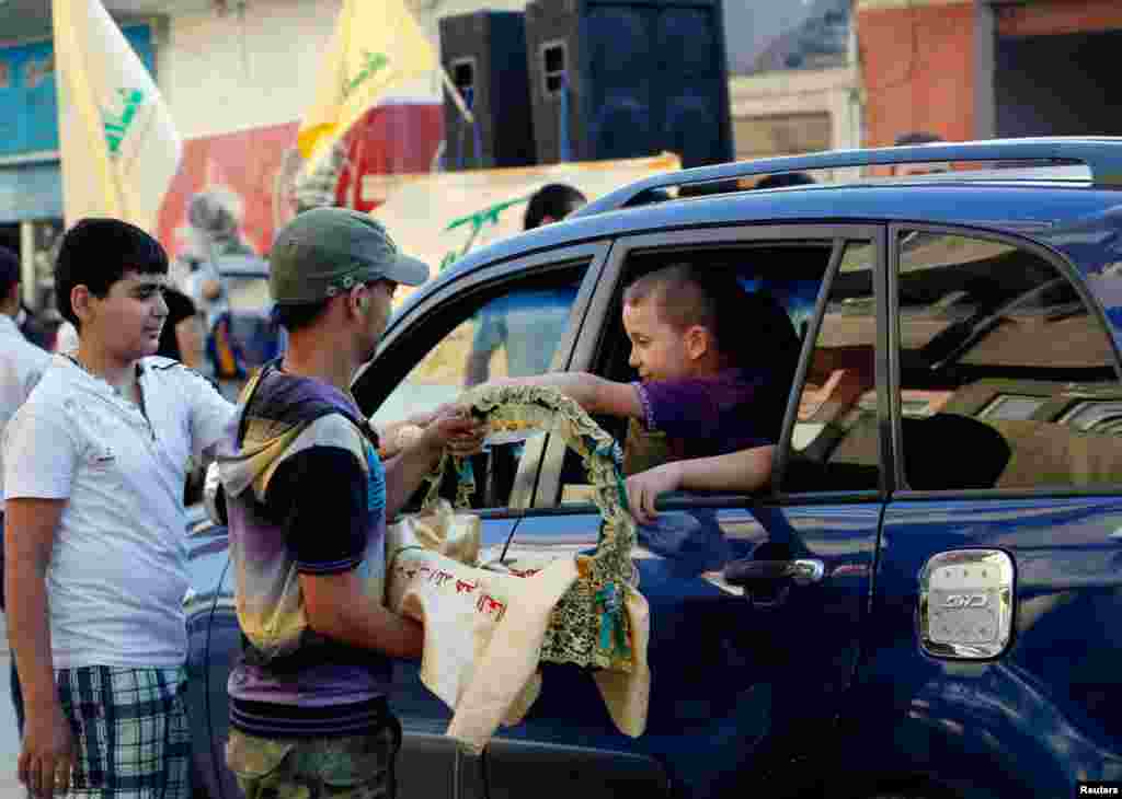 Supporters of Hezbollah distribute sweets as they celebrate after the Syrian army took control of Qusair with Hezbollah&#39;s support from rebel fighters, in the Shi&#39;ite town of Hermel, Lebanon, June 5, 2013. 