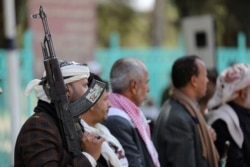 A Houthi supporter holds a rifle as he attends a ceremony held to send donated clothes to Houthi fighters at the frontlines against government forces, in Sanaa, Yemen, Nov. 24, 2020.