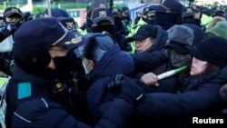 Pendukung Presiden Korea Selatan yang dimakzulkan Yoon Suk Yeol bentrok dengan petugas polisi saat pihak berwenang berusaha melaksanakan surat perintah penangkapan, di Seoul, Korea Selatan, 15 Januari 2025. (Foto: Tyrone Siu/Reuters)