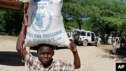 A Haitian child carries a bag of food during a food distribution from the United Nations World Food Program, Programme Alimentaire Mondial in Balan a suburb of Ganthier, (File).