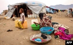 FILE - A woman washes clothes at a make-shift camp for displaced Yemenis who fled fighting between the Houthi rebels and the Saudi-backed government, in the Abs district of the northwestern Hajjah province, Aug. 17, 2019.