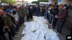 Palestinians attend funeral prayers over the bodies of those killed in overnight Israeli airstrikes on the Maghazi refugee camp at Al-Aqsa Hospital in Deir al-Balah, central Gaza Strip, Dec. 28, 2024.