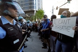 FILE - People confront police officers during a protest over the death of George Floyd in Chicago, May 30, 2020.