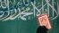 FILE - A Virginia social studies class learning about Arabic calligraphy was told to write "There is no god but Allah and Muhammad is the messenger of Allah." That message is seen here, from a 2008 banner in Sana'a.