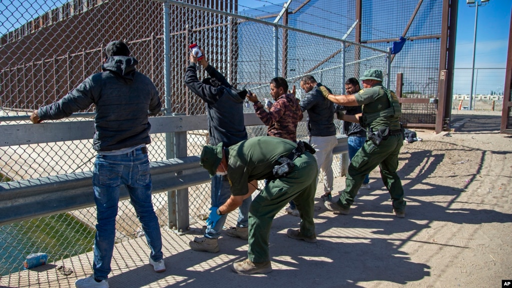 ARCHIVO - Agentes de la Patrulla Fronteriza palpan a migrantes cuando ingresan a El Paso, Texas, desde Ciudad Juárez, México, el 10 de mayo de 2023.